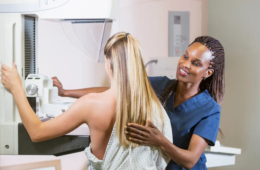woman being helped at a mammogram by a nurse